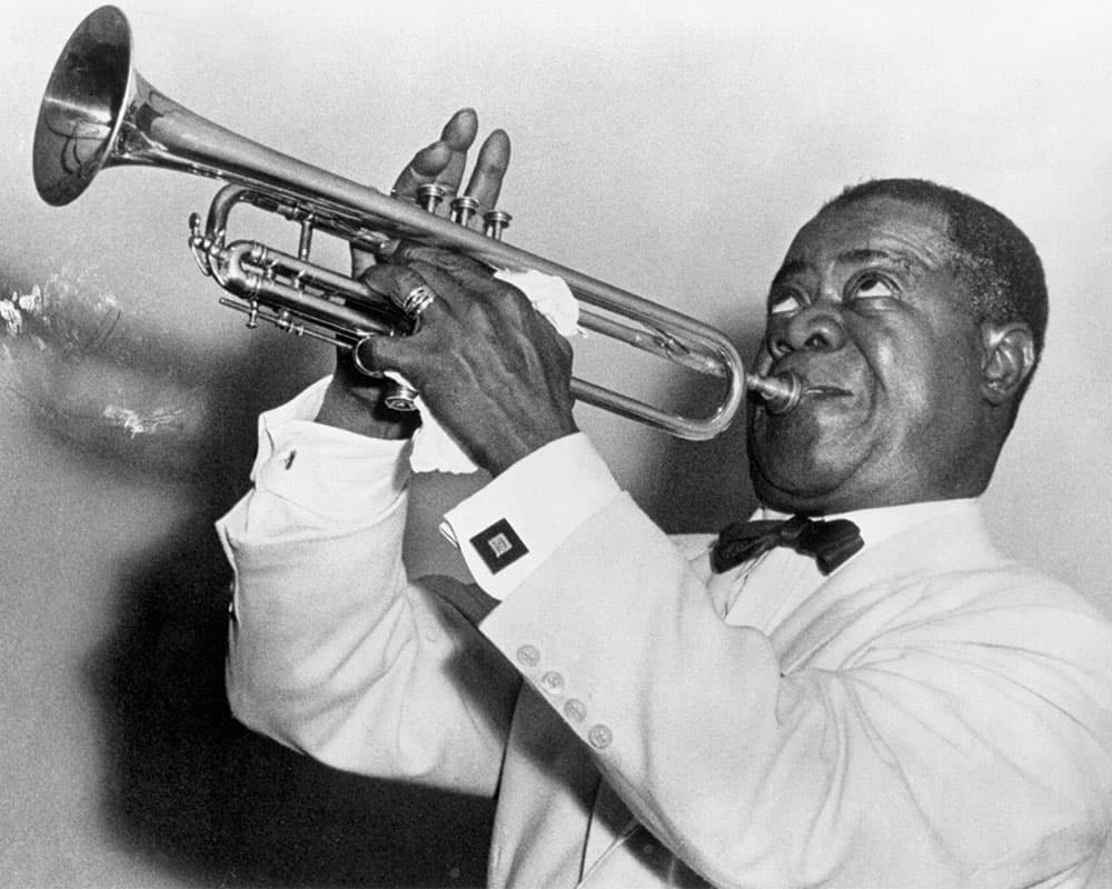 Black & white photo of Louis Armstrong playing the trumpet