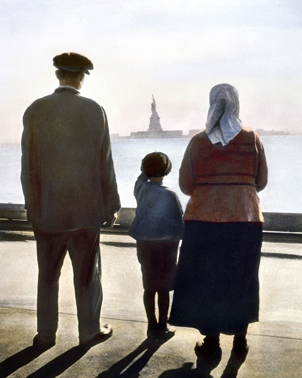 immigrants standing on the shore looking at the Statue of Liberty