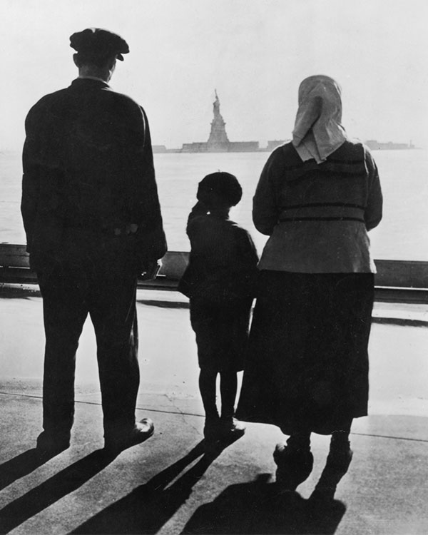 A young boy points at the statue of liberty