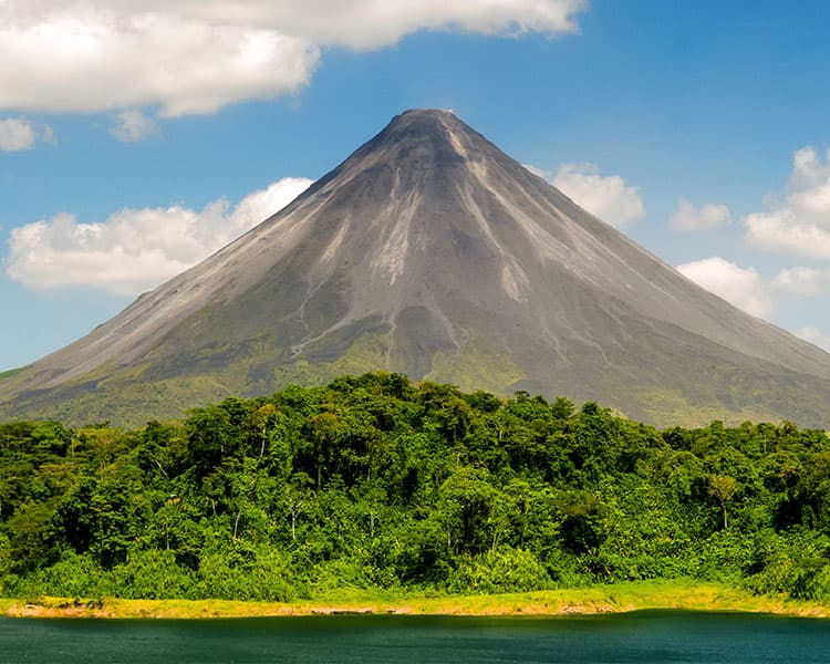 Arenal Volcano towers above a forest