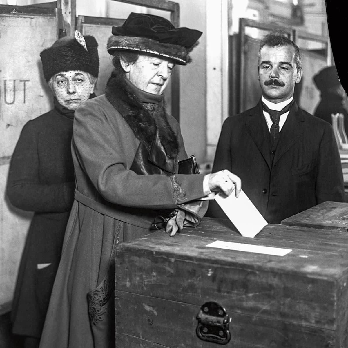 A woman casts her vote into a ballot box