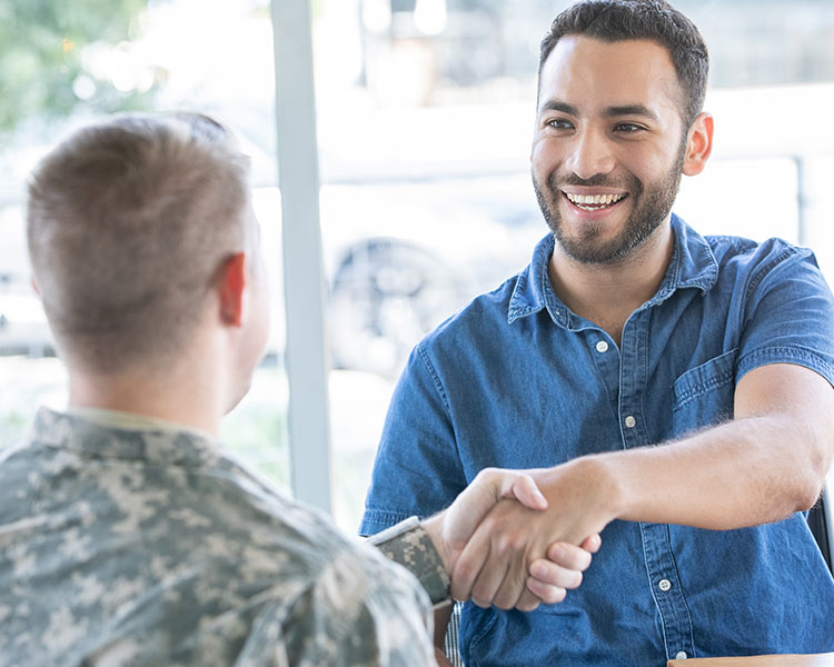 A soldier shakes a person’s hand