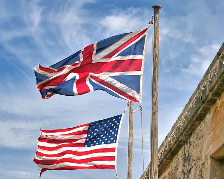 A British flag and an American flag wave in the wind.