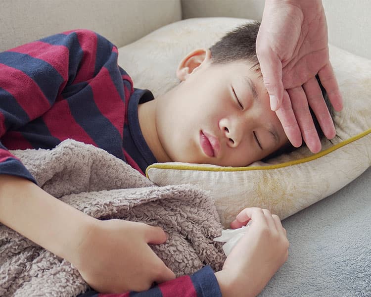 Parent checking their child&apos;s forehead to see if they are sick