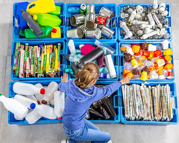 Student organizing recyclables into bins