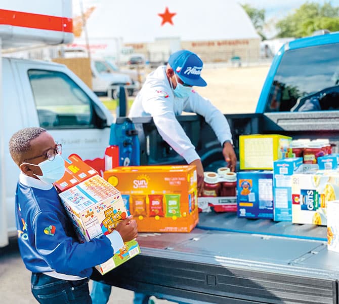 Enlargeable photo of father and son loading their truck with donations