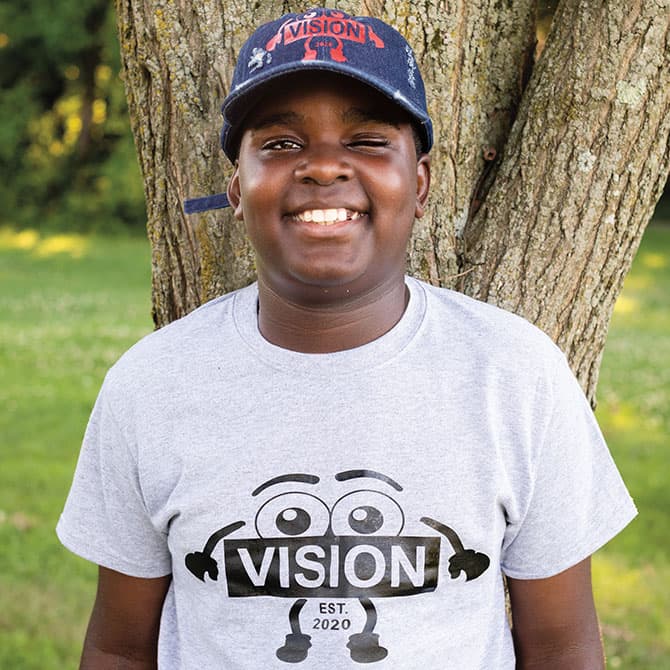 Enlargeable photo of Isaiah wearing a tee shirt from his clothing line