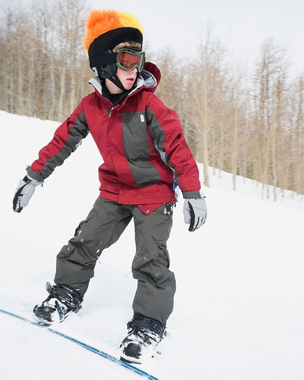 young boy snowboarding