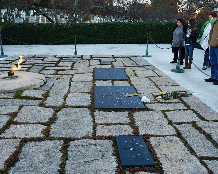 People at a gravesite where a fire is constantly lit