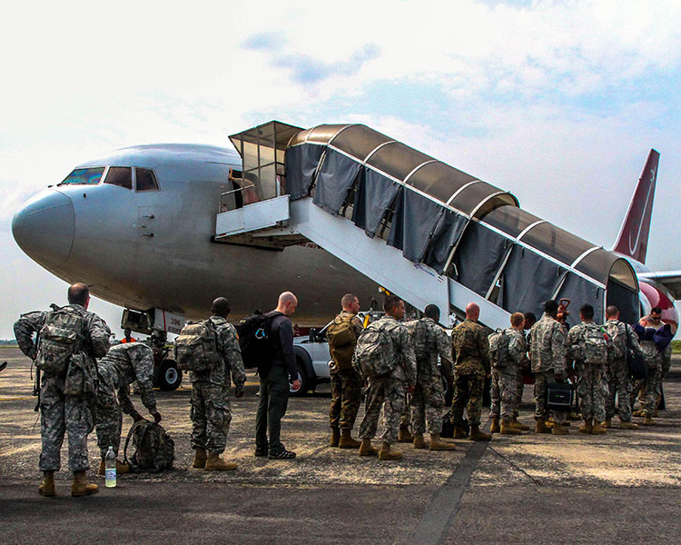 Soldiers lined up to board an aircraft