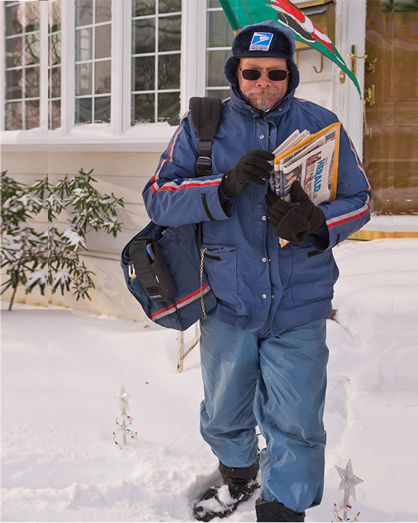 A postman delivering mail in the snow