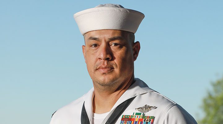 A man in a white sailor uniform with badges on it