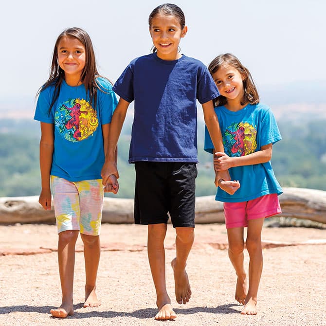 Enlargeable photo of three siblings holding hands and smiling