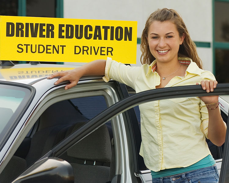 Teenager standing next to car. Text reads: Driver Education Student Driver