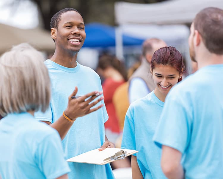 A group of people wearing the same shirt and having a conversation