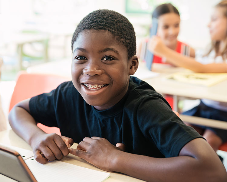 Photo of a student smiling at their desk