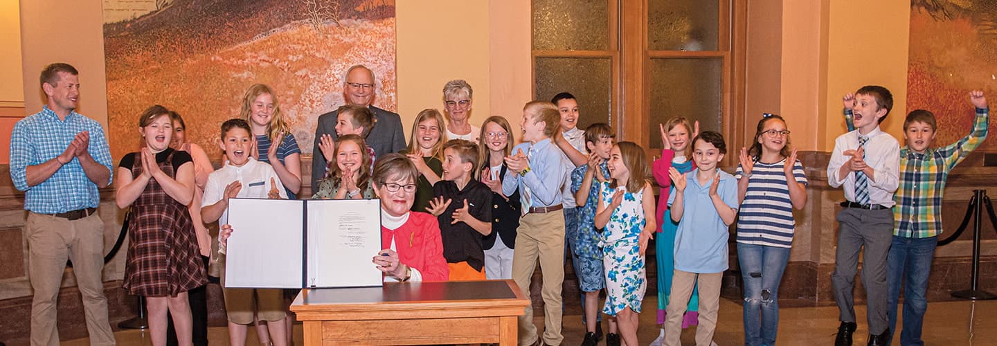 Photo of a class of students posing with an official document