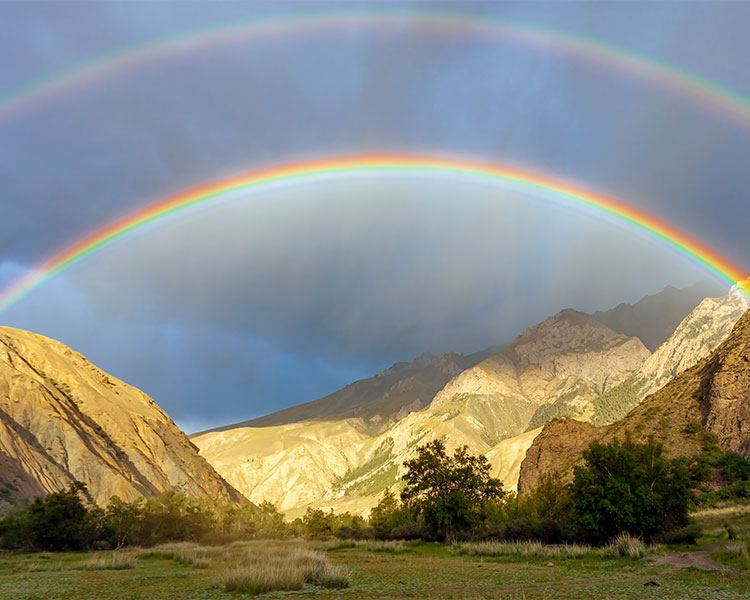 Photo of a double rainbow over a mountain range