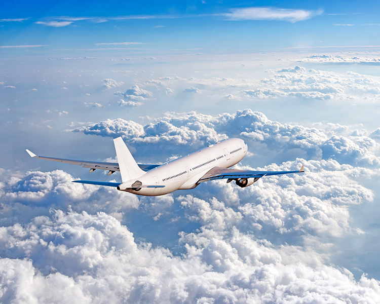 Image of a plane flying over the clouds