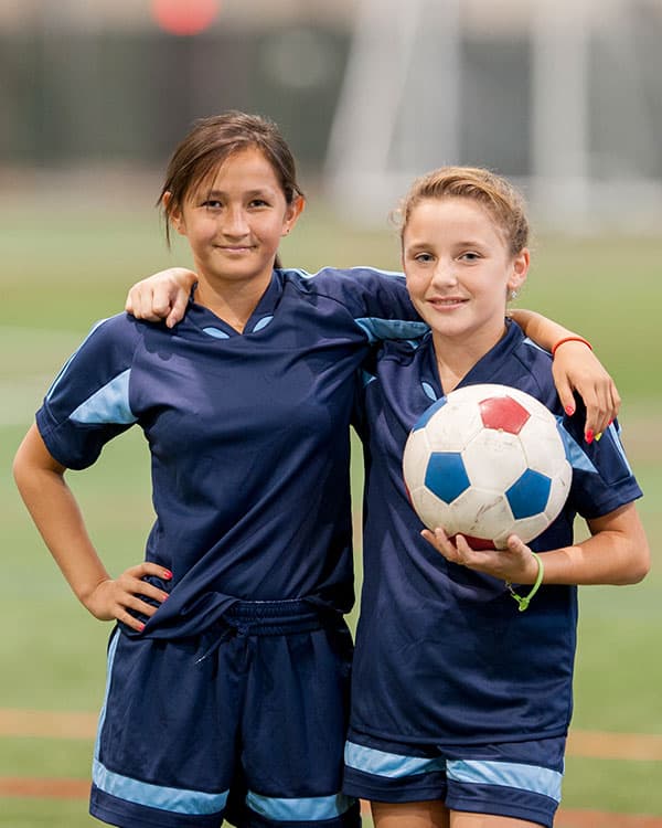 Photo of two soccer players with arms around each other