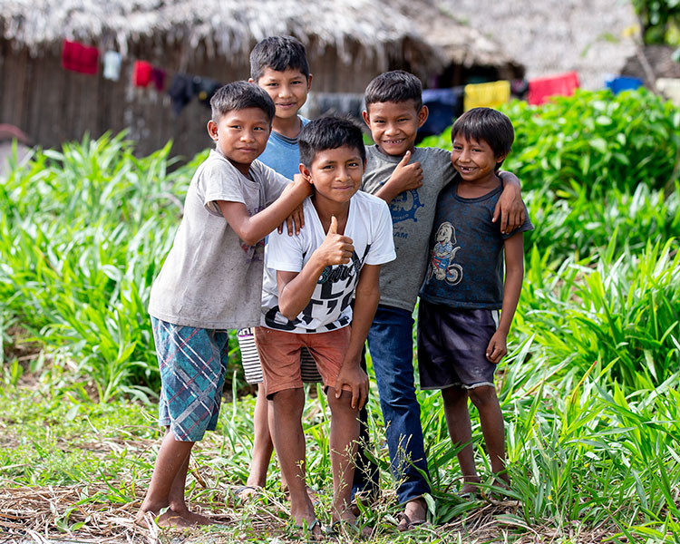 Image of five kids posing for a photo in a village