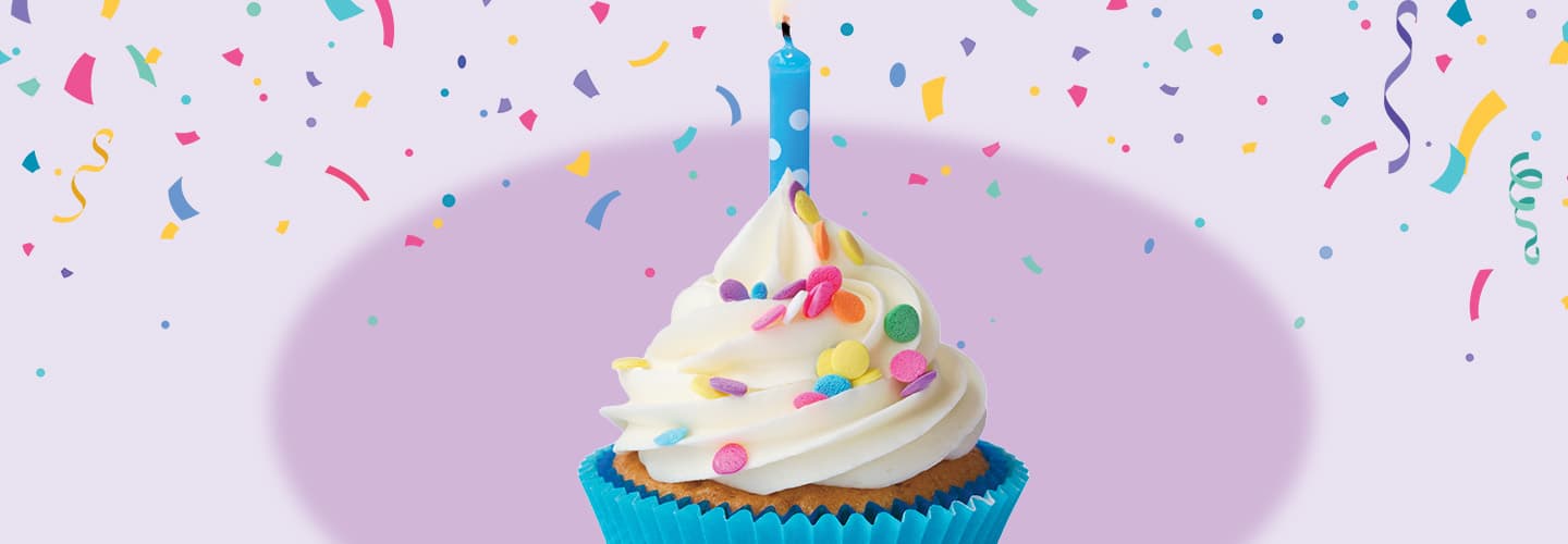 Image of birthday cupcake with candle on it and confetti in background